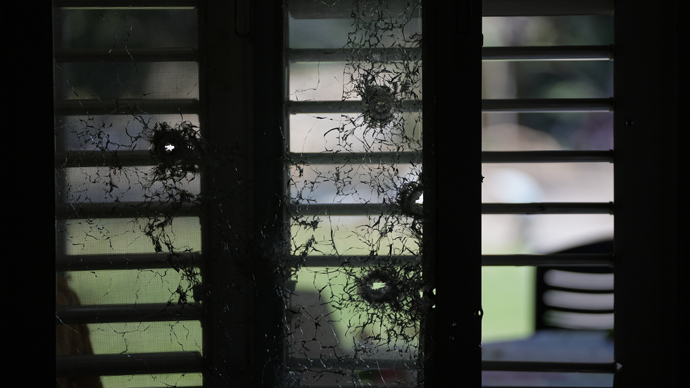Ett fönster med skotthål i en byggnad på den israeliska kibbutzen Kfar Azza på tisdagen. Enligt vittnen togs flera civila gisslan från kibbutzen i lördags.