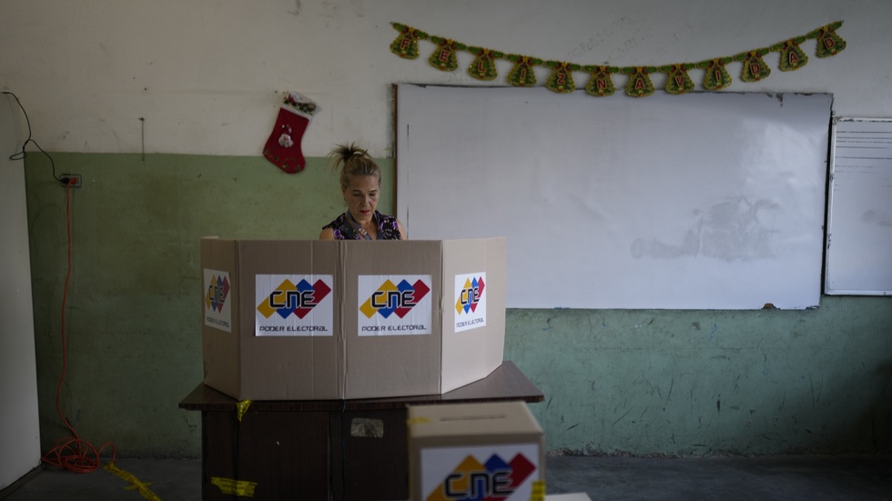 En kvinna i Venezuelas huvudstad Caracas lägger sin röst i folkomröstningen om Essequibo.
