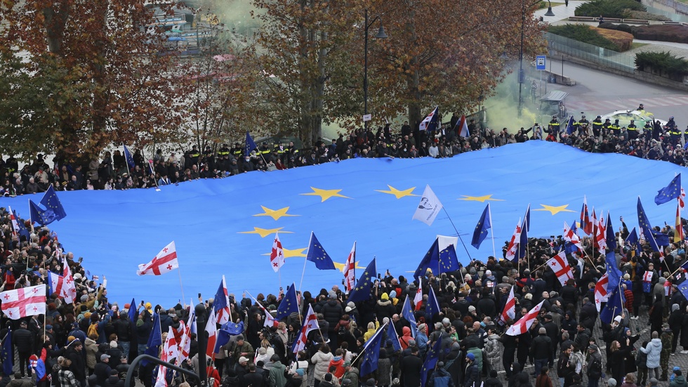 Demonstranter i Georgiens huvudstad Tbilisi vecklar ut en gigantisk EU-fana i en manifestation för EU-medlemskap.