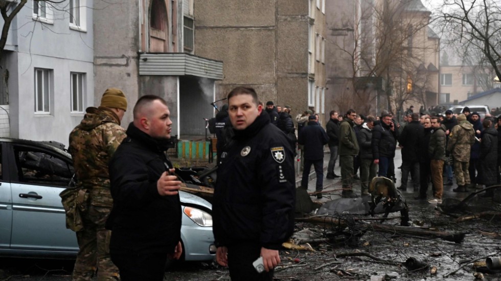Militär och polis på platsen där en helikopter kraschade strax utanför Kiev på onsdagsmorgonen.