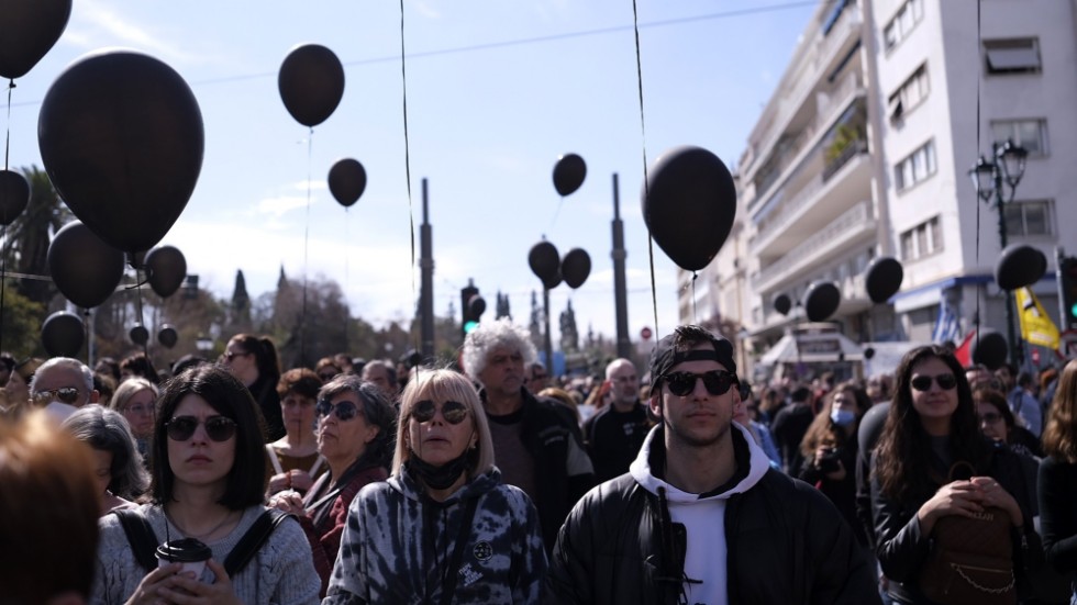 Demonstranter med svarta ballonger håller en tyst minut utanför parlamentsbyggnaden i Aten.