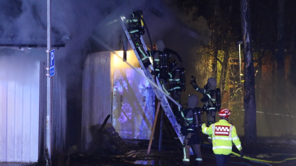 Rökdykare och brandpersonal kämpar mot lågorna.
