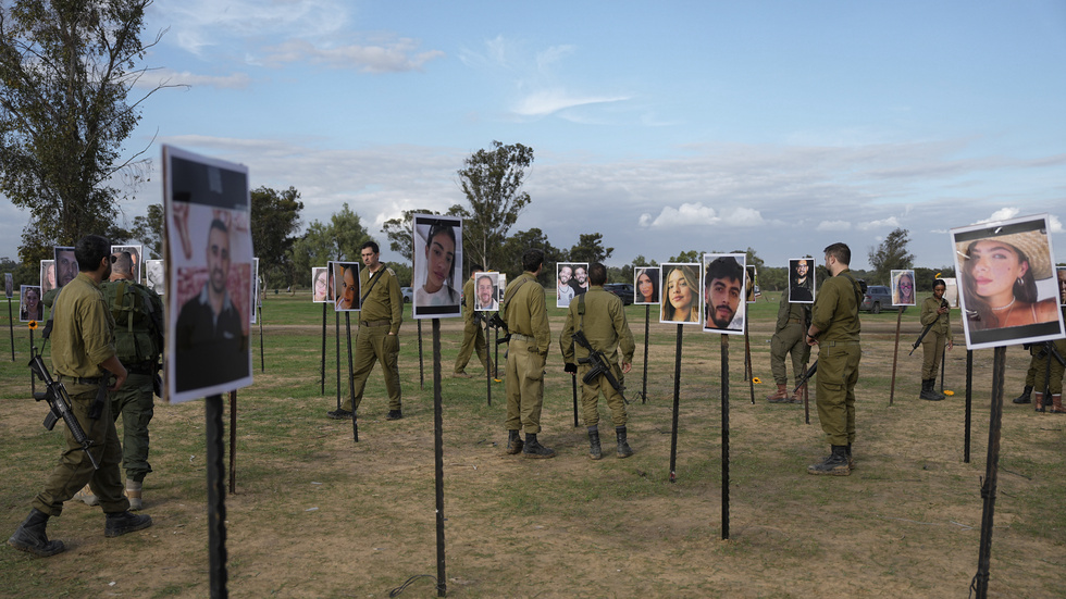 Israeliska soldater och andra går omkring bland bilder på människor som dödades eller togs gisslan av Hamas under den blodiga attacken mot Israel den 7 oktober.