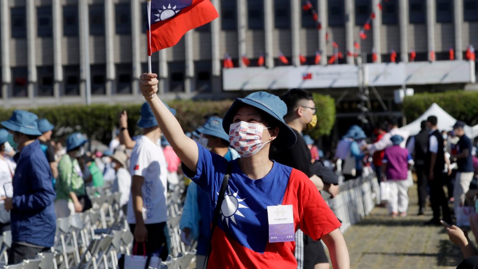 En kvinna som håller Taiwans flagga i samband med nationaldagsfirandet nyligen – ett firande som sker i skuggan av kinesiska aggressioner. 