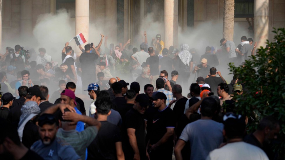 Säkerhetsstyrkor skjuter tårgas mot Sadr-anhängare som stormat regeringspalatset i Bagdad, 29 augusti.