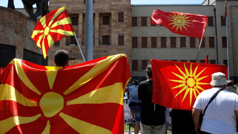 Nodmakedonska flaggor, både av nyare och äldre modell, framför parlamentet i huvudstaden Skopje. Arkivbild.