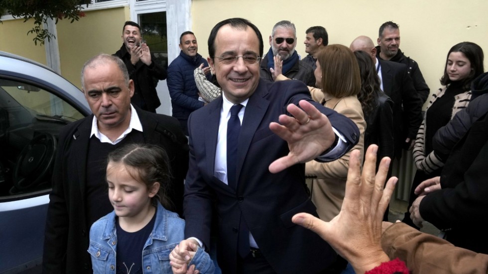 Cyperns förre utrikesminister Nikos Christodoulides hälsar på väljare utanför sin vallokal på söndagen.