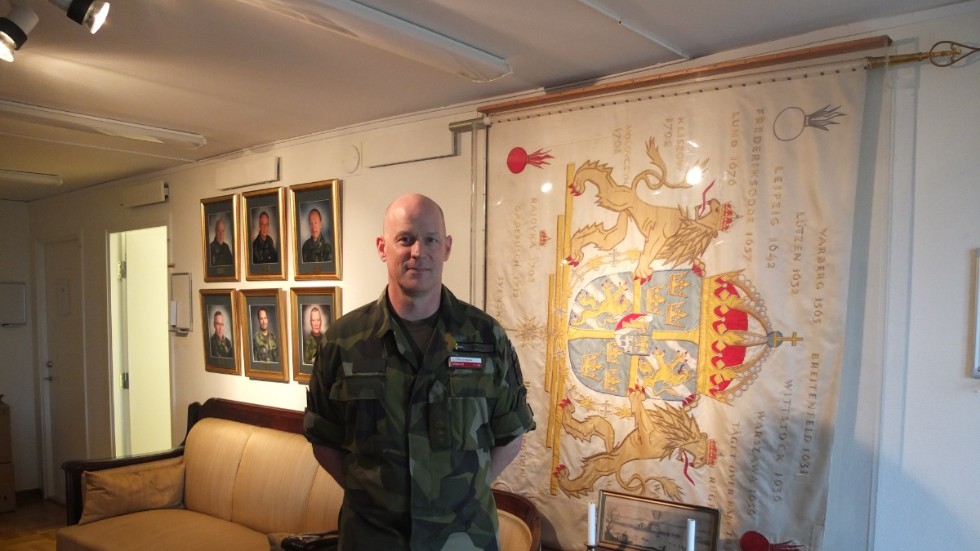 Överstelöjtnant Björn Ryman vid den pampiga regementsfanan.