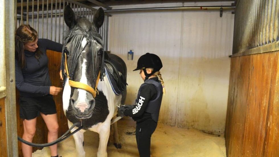 Victoria Nöjd, instruktör på VIRF hjälper Tilde Wideen att sadla hästen Sonja.