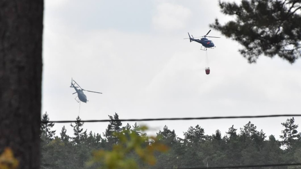 Helikoptrar vattenbombar branden i närheten av Fallhult.