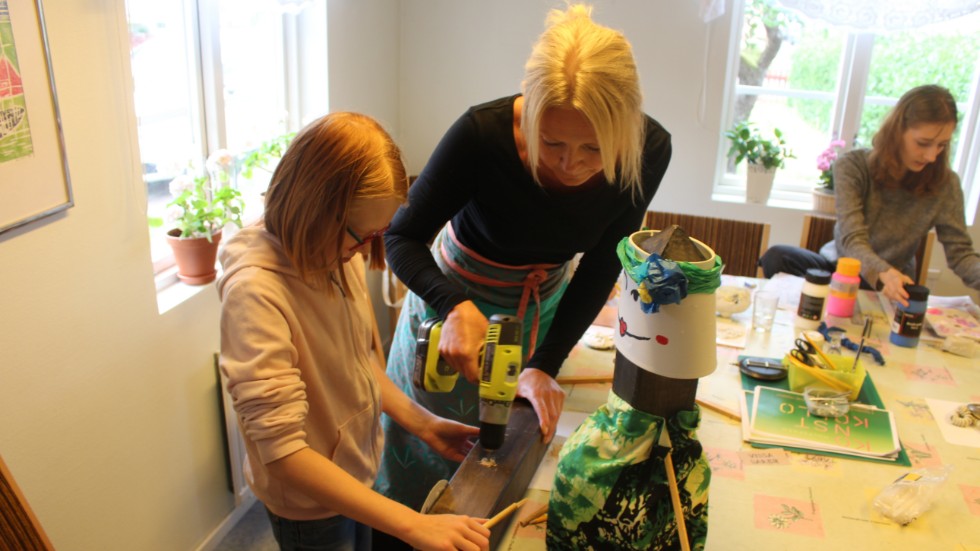 Ledaren Linda Rothstein hjälper 12-åriga Freja Bergström med en av hennes skapelser under konstkollot i Hultsfred.