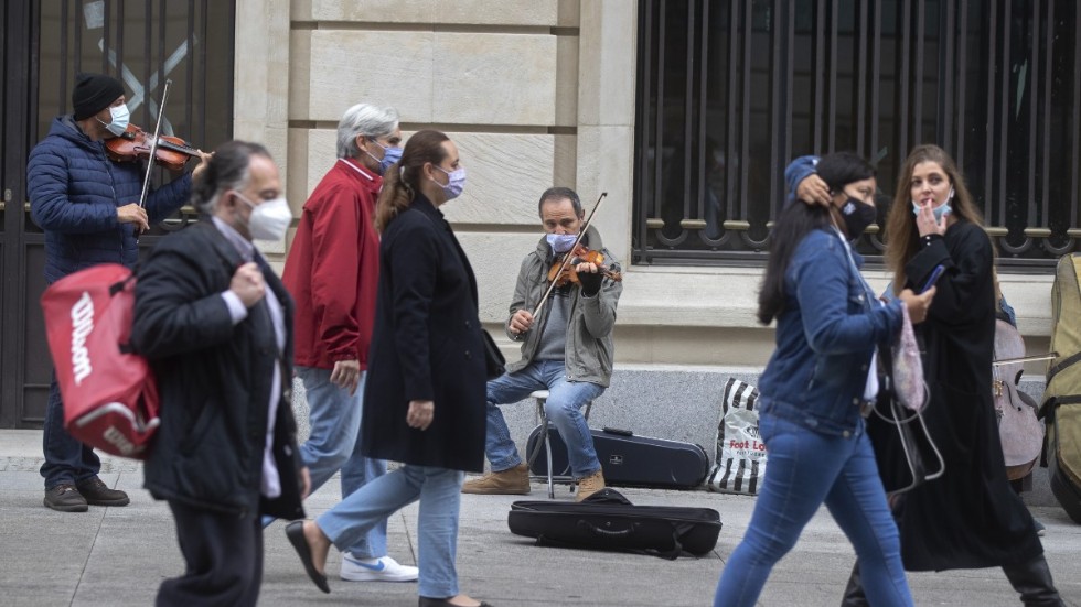 En gatumusikant spelar för förbipasserande i Spaniens huvudstad Madrid. Bilden är från i söndags.