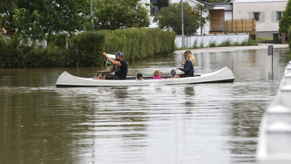 Augusti 2021. Gävlefamiljen paddlar kanot genom ett översvämmat villaområde efter nattens kraftiga skyfall. 
