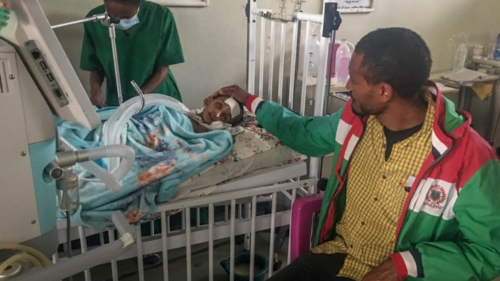 Rahwa, 4 år, tröstas av sin far medan hon ligger inlagd på ett sjukhus i Tigrays regionhuvudstad Mekele. Hon drabbades först av näringsbrist och därefter av en svår form av tuberkulos. Bild från den 4 oktober.