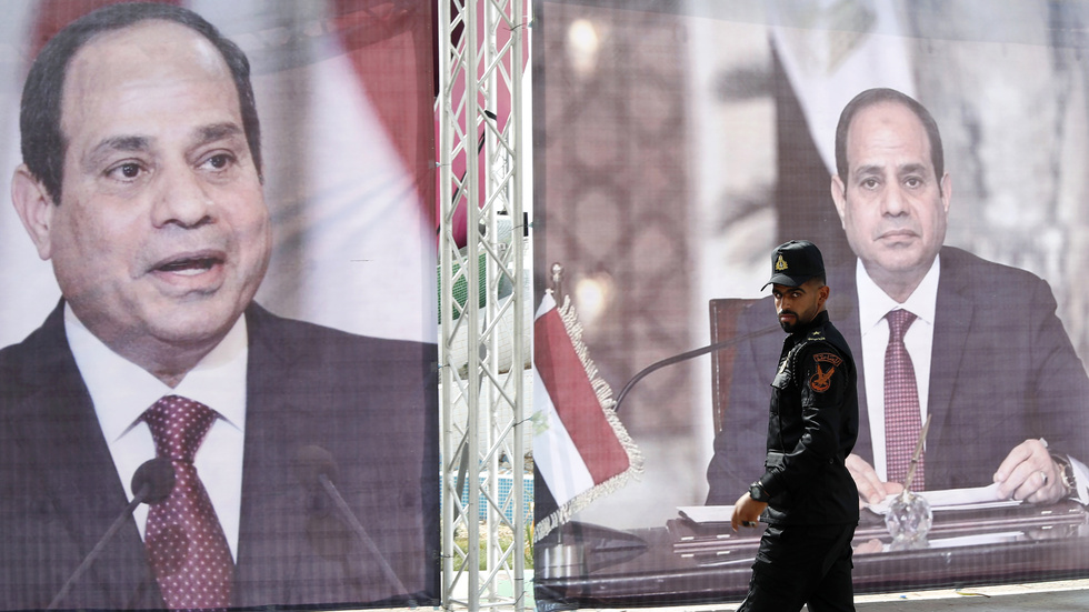 En polis från Hamas patrullerar framför ett porträtt på Egyptens president Abd al-Fattah al-Sisi i maj 2021, i samband med att Egyptens underrättelsechef besökte Gaza.