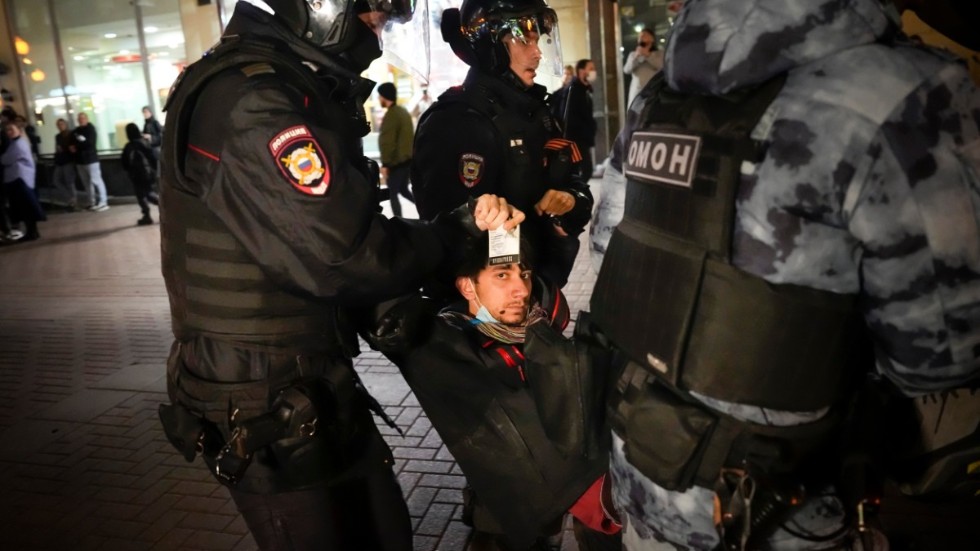 Poliser bär iväg en manlig demonstrant i Moskva. Ryssar protesterade mot den utökade krigsmobiliseringen i flera städer.