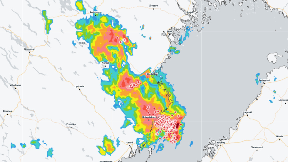 SMHI's radar image shows the storm moving across Norrbotten and Västerbotten at 9.45pm. Redder colors indicate heavier precipitation, and each plus sign represents a lightning strike.