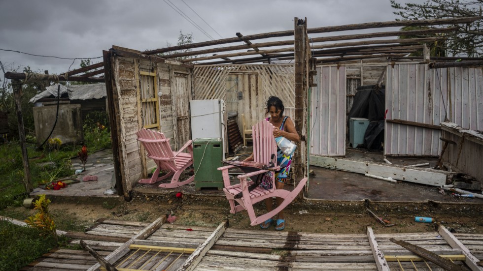 En kvinna försöker rädda ägodelar från sitt orkanrammade hus i Pinar del Río på västra Kuba.