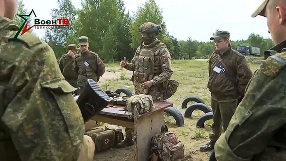 På fotot taget från en video som släpptes av Belarus försvarsdepartement på fredagen syns en instruktör från privatarmén Wagner tala till belarusiska soldater under en övning.