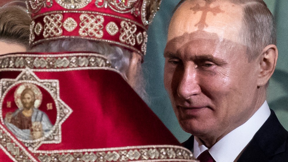 President Vladimir Putin, vänd mot patriark Kirill, under en påskgudstjänst 2019.