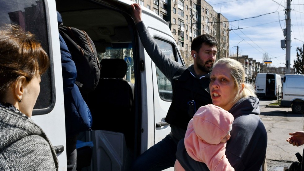 Kvinna med barn går på bussen för att fly Kramatorsk under lördagen.