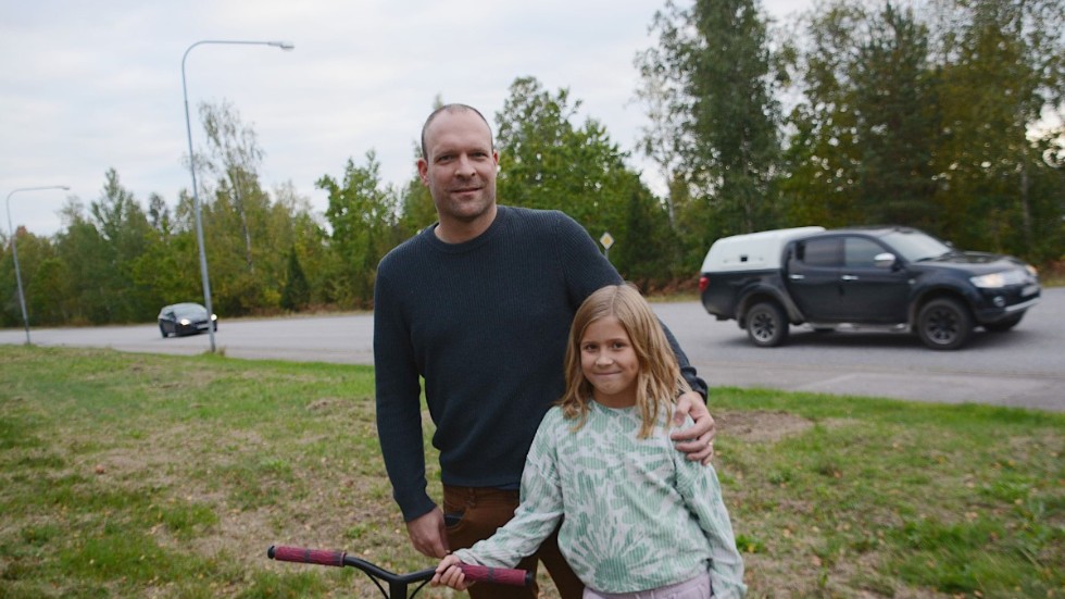 Christian Bauer tillsammans med dottern Lilly, 8 år, intill den livligt trafikerade gata där minst vartannat fordon kör för fort. 