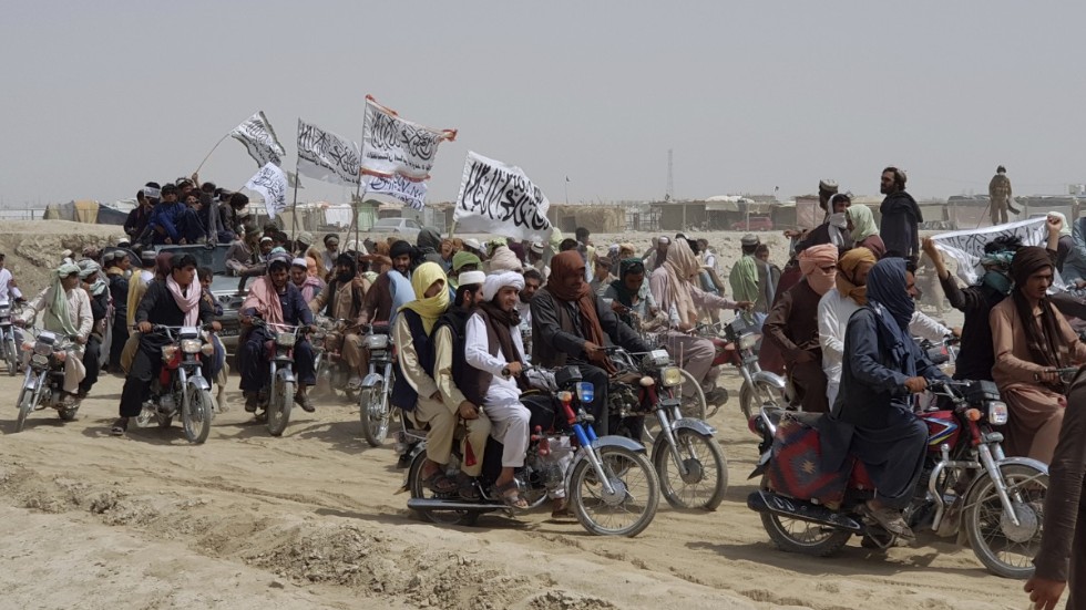 Talibananhängare bär rörelsens vita flagga vid gränsområdet mellan Afghanistan och Pakistan den 14 juli i år. Talibanerna, som uppskattas ha ett stöd på cirka 15 procent bland den afghanska befolkningen, har under juli intagit flera viktiga gränsövergångar i de upptrappade striderna.