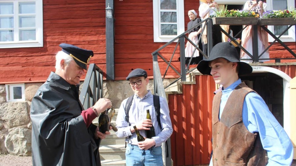 Länsman (Bengt Sundin) kollar vad bönderna (Ludvig Strömberg och David Stridell) har i flaskorna