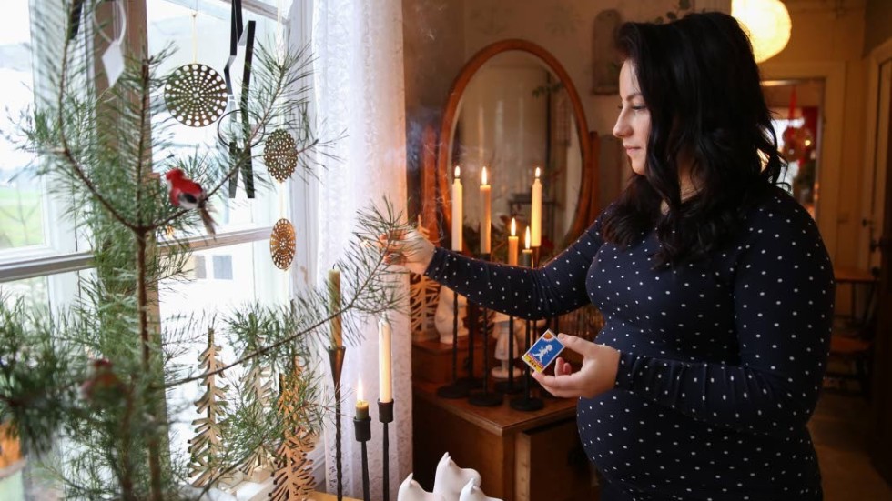 Louise Isaksson tänder ljus för julstämning i Stiliga Stugan, hennes inredningsbutik på landet.