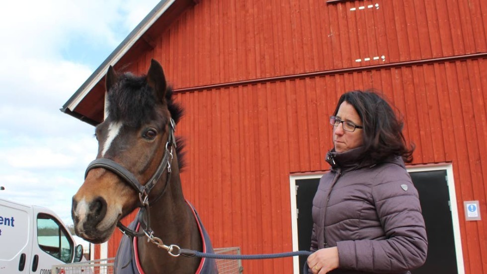 Jennie Norström med privathästen Sörbys Yust Lady utanför det totalrenoverade stallet.