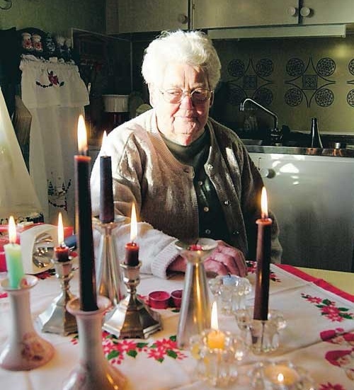Karin Samuelsson, 88, håller värmen med brinnande ljus. Foto: Janne Strömsten