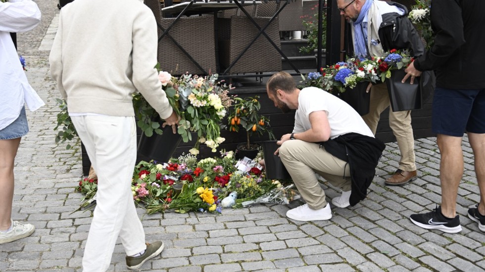 Människor lägger ned blommor på Donners plats i Visby.