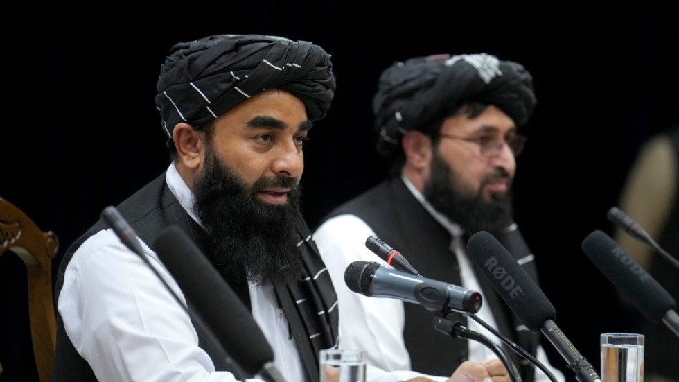 Zabiullah Mujahid (vänster), talesperson för talibanernas regering i Afghanistan, under en presskonferens i torsdags, då massmötet inleddes.
