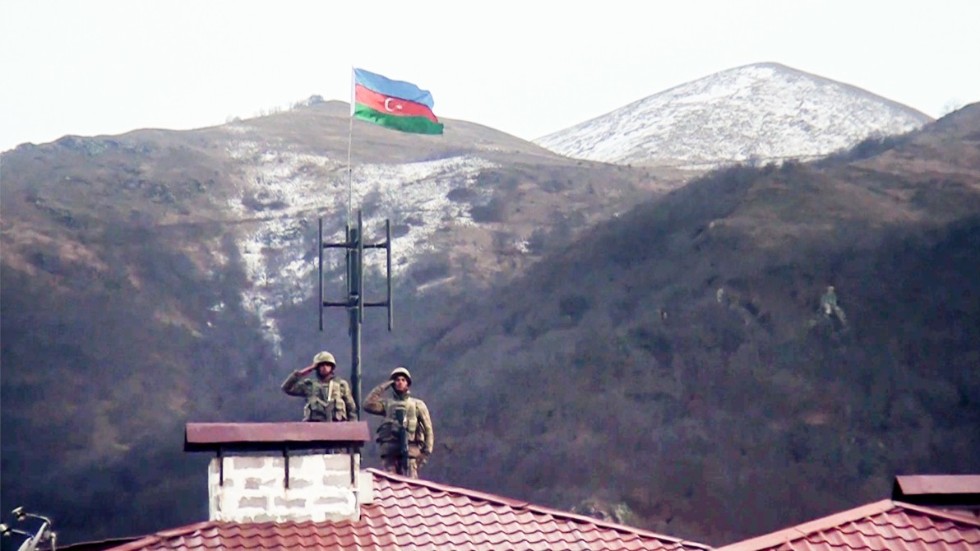 Azeriska soldater gör honnör sedan armén gått in i den övergivna staden Kalbajar, ett av de områden som Armenien lämnat över kontrollen av. Bilden kommer från azeriska försvarsdepartementet.