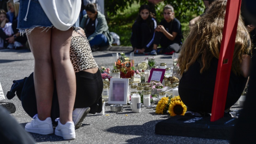 Folk samlas vid blommorna och ljusen på platsen där en tolvårig flicka sköts ihjäl vid en bensinmack i Hallunda i Botkyrka, söder om Stockholm natten mot söndagen.