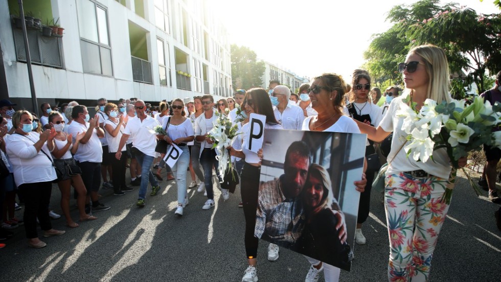 Hustrun till den 59-årige busschaufför i Frankrike som i söndags misshandlades till döds när han uppmanade en grupp passagerare att sätta på sig munskydd, håller ett foto av sin make.