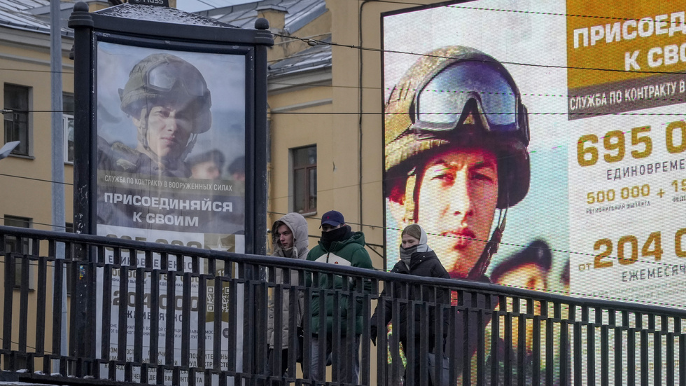 Några unga personer i S:t Petersburg promenerar förbi reklamtavlor där de uppmanas ta värvning i armén. Bilden togs den 22 november.