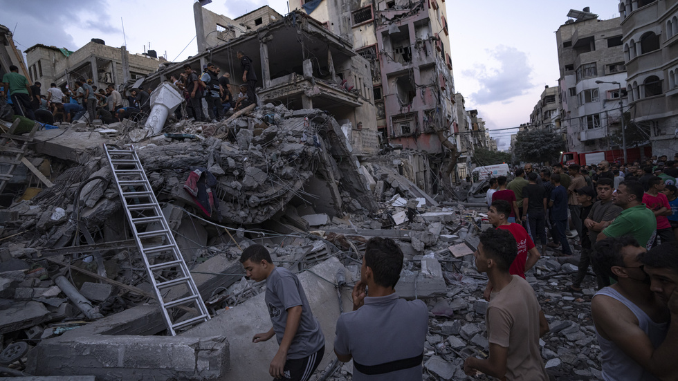Chockade palestinier ser på resterna av ett hus som bombats av Israel i Hamasstyrda Gaza.