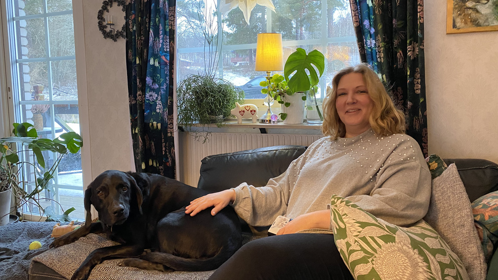 Ellinor Widerberg kopplar av hemma i soffan med hunden Loke.