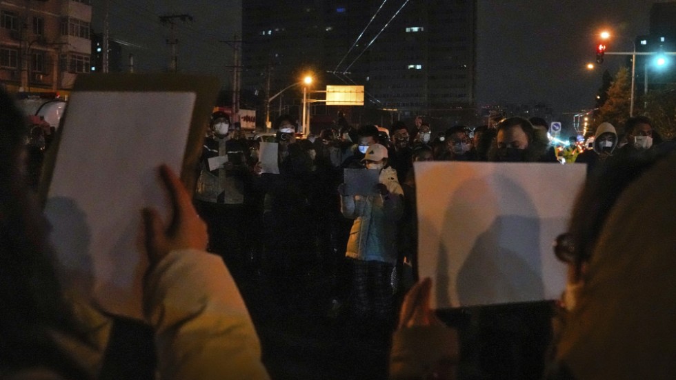 Tomma A4-papper hölls upp vid en demonstration mot covidrestriktionerna i Kina, i huvudstaden Peking i söndags.