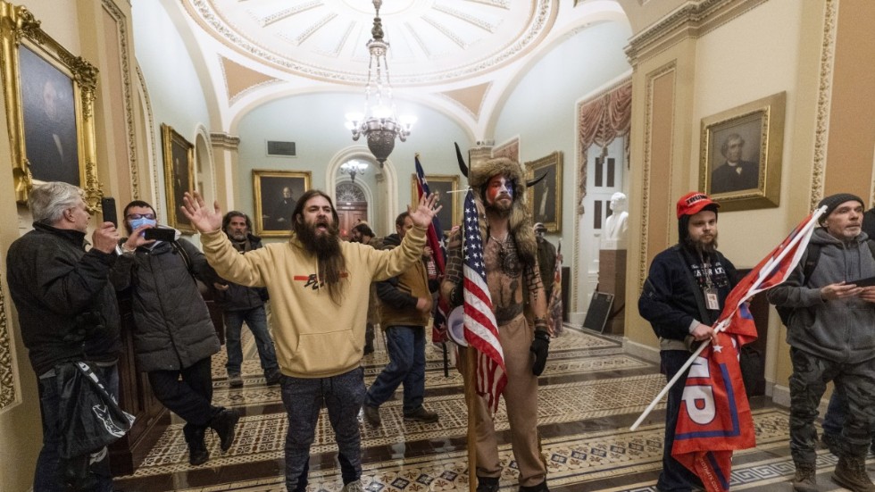 Här syns några av personerna som stormade USA:s kongressbyggnad den 6 januari i år. Mannen med den hornprydda hatten är en känd Qanon-aktivist.