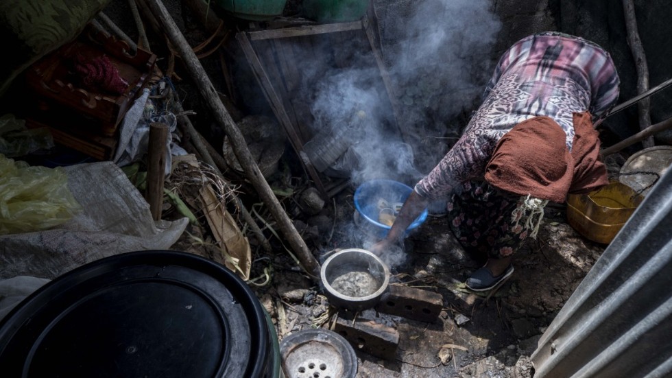 En etiopisk tvåbarnsmamma, som förlorat sitt arbete på grund av covidkrisen, lagar middag till sin familj. Hon bor i ett tält i huvudstaden Addis Abeba och lever på motsvarande 34 USA-dollar i månaden.