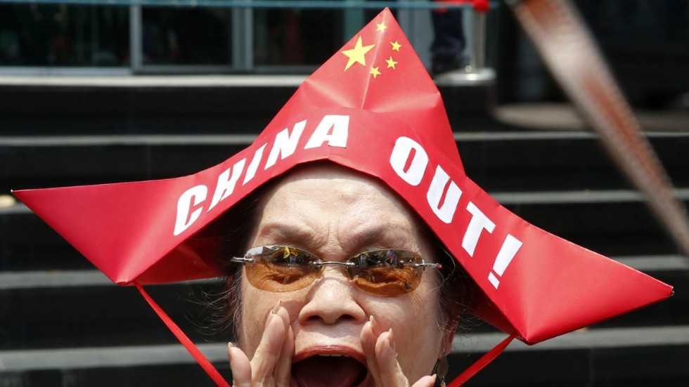 En upprörd filippinsk kvinna protesterar utanför det kinesiska konsulatet i Manila mot att Kina fortsätter att fiska i vad Filippinerna anser vara den del av Sydkinesiska havet som tillhör dem – trots ett FN-beslut som förbjuder det. Juli, 2019.
