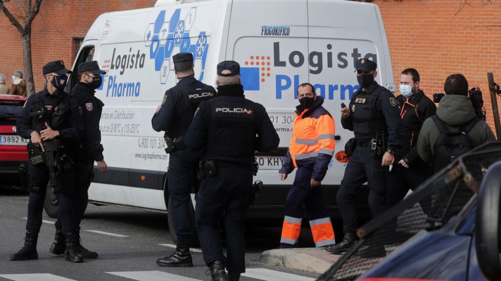 Polis bevakar en leverans av coronavaccin vid ett äldreboende i Madrid. Bilden är från i söndags.