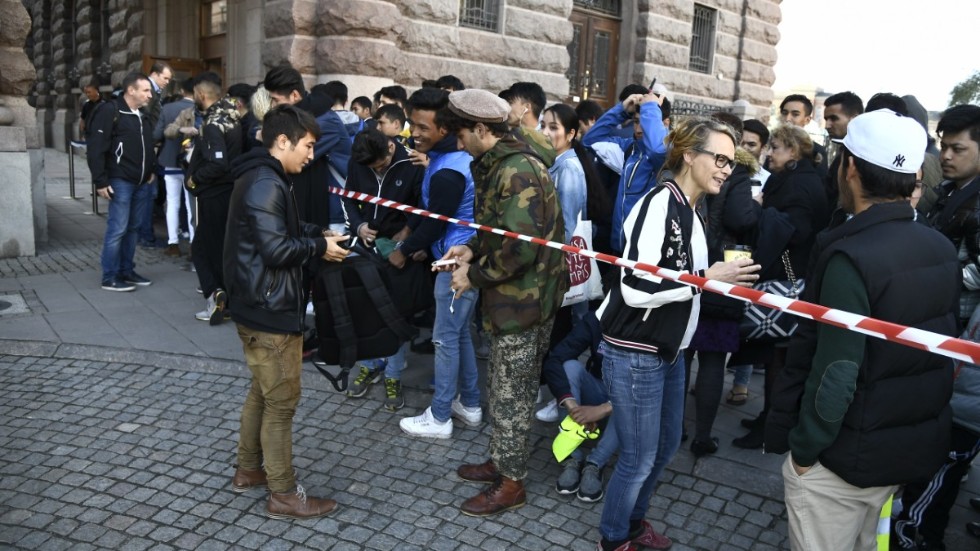Unga afghanska män i Sverige på väg in i riksdagshuset.