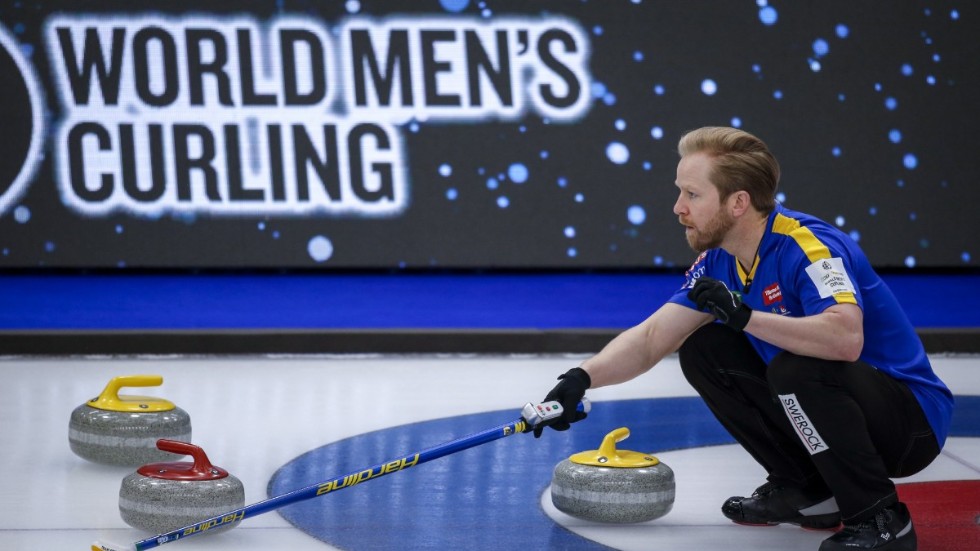 Sveriges skipper Niklas Edin visar hur lagkamraterna ska slå en sten under curling-VM.