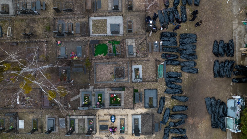 Poliser identifierar dödade civila på en kyrkogård i Butja utanför Kiev, i onsdags.