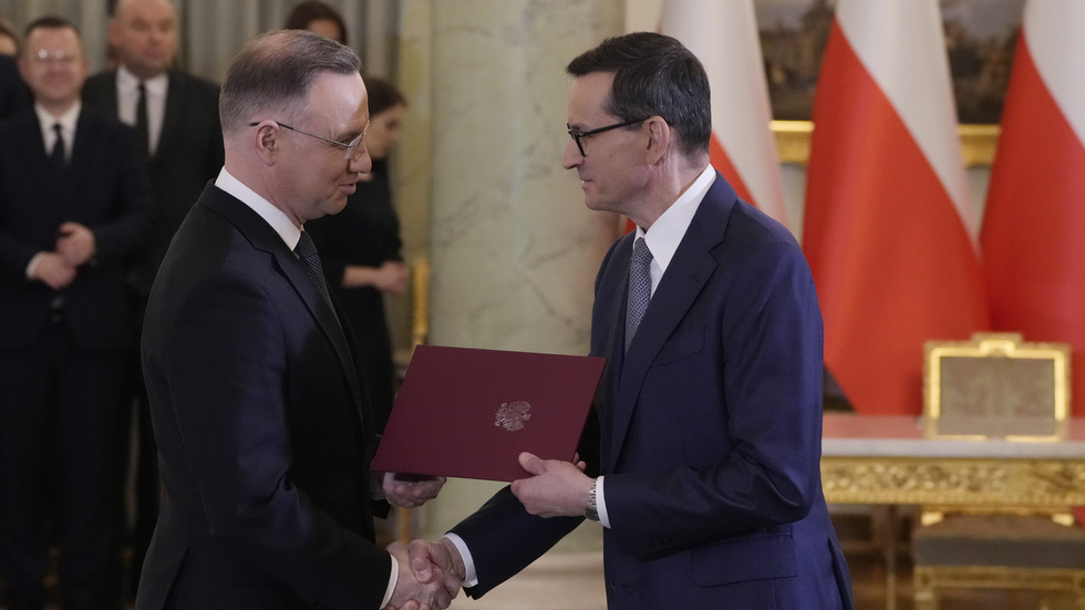 Polens president Andrzej Duda, till vänster, skakar hand med premiärminister Mateusz Morawiecki efter det att den sistnämnde svurits in på sin post på måndagen.