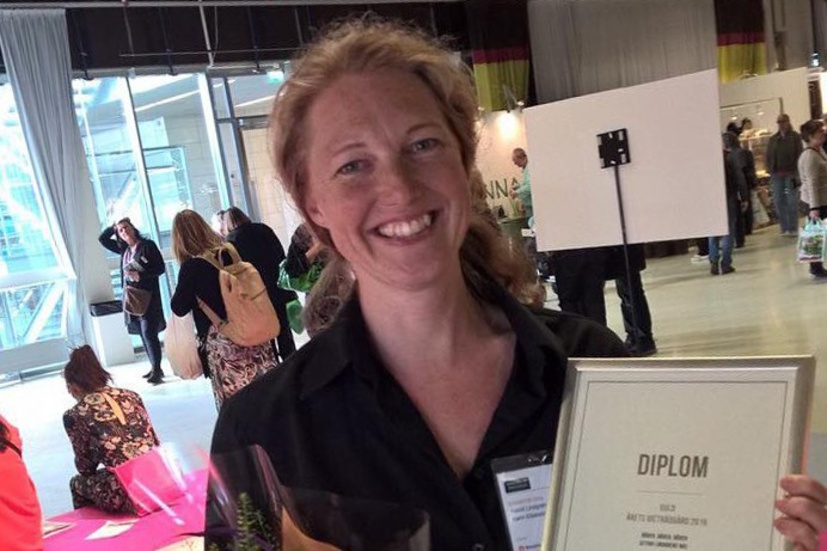 Karin Eliasson, konstnärlig ledare och trädgårdsmästare på Astrid Lindgrens Näs, med diplomet i högst hugg.