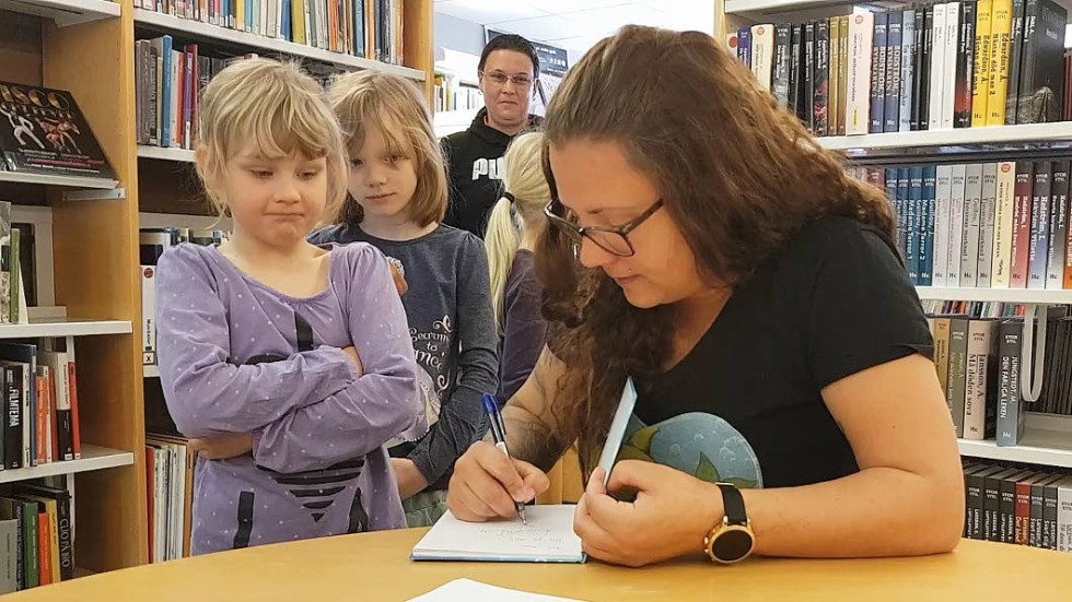 Barnen köar för att få en signerad bok om hajar av Emmalill Frank.
